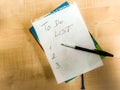 to do list checklist hand written on notepad paper lay on wooden table. fountain pen laying above Royalty Free Stock Photo