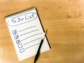 to do list checklist hand written on notepad paper lay on wooden table. pen lay on notepad Royalty Free Stock Photo