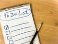 to do list checklist hand written on notepad paper lay on wooden table. pen lay on notepad Royalty Free Stock Photo