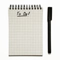 To do list on gridded spiral notepad with pen, urgent - isolated on white