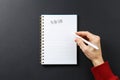 To do list notebook with black pen in hands