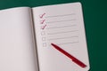 To-do list with several points. Open notebook on green background Royalty Free Stock Photo