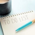 To do list, square shpt. A paper notepad with coffee and a turquoise blue pen