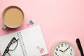 To do list written in a notebook. Notebook with an to do list on pink with cup of coffee and clock Royalty Free Stock Photo