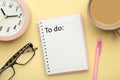 To do list written in a notebook. Notebook with an to do list on pink with cup of coffee and clock Royalty Free Stock Photo