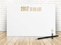 2017 To do list year text on white paper poster with black pencil and lightbulb on wood plank floor and white brick