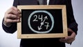 24 to 7 drawing on blackboard, businessman holding sign, business time concept Royalty Free Stock Photo