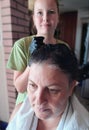 To dye woman& x27;s hair black by her daughter Royalty Free Stock Photo