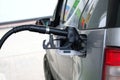 To fill car with fuel in petrol station. Pumping gasoline fuel in gray car at a gas station. Close up Royalty Free Stock Photo