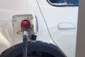 To fill up the car with gasoline at the gas station, a man pours gasoline into the tank of a white car in winter