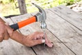 To hammer a nail with a hammer. Older worker carpenter