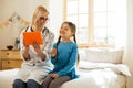 Beaming pediatrician laughing and having fun with a small girl.