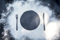 To make food in the morning sunrise. on black marble background with flour covered with silhouette plate fork knife appliances. Royalty Free Stock Photo