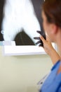 To make it right, we have to see whats wrong. A female medical professional looking at an x-ray.