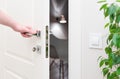 To open the door. Modern white door with chrome metal handle and a man`s arm Royalty Free Stock Photo