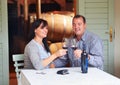 To our future. A happy mature couple toasting with some red wine while sitting at a table on a wine cellar. Royalty Free Stock Photo