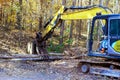 To prepare for construction home builder uses a tractor to uproot trees in forest Royalty Free Stock Photo