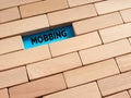 To reveal hidden mobbing concept. The word mobbing surrounded by wooden blocks Royalty Free Stock Photo