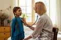 A girl breathing out while a physician examining her lungs