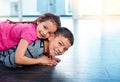 About to take a trip around the house. an adorable little girl lying down piggy back on her brother while playing at Royalty Free Stock Photo