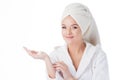 To use the cream after a shower. Portrait of a young attractive woman in a Bathrobe and a towel on her head. Royalty Free Stock Photo