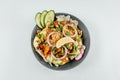 To view closeup of roasted orange bell peppers, onion, radish, lemon and lettuce in a black bowl