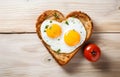 toast bread heart shape filled with fried egg and smile with ketchup on white wooden table top view Royalty Free Stock Photo