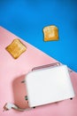 Toast bread POPs out of the toaster on a blue and pink background. vertical photography