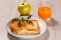 Toast with butter and cheese on white plate, apple and glass of