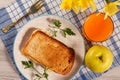 Toast with butter and cheese on white plate, apple, glass of ora Royalty Free Stock Photo