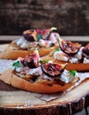 Toast with caramelized onions, goat cheese, jamon and grilled figs. selective focus