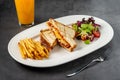 Toast with cheese, egg and Turkish sausage served with salad and french fries on white plate Royalty Free Stock Photo