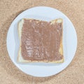 Toast with chocolate spread on white plate on wooden plate background. Royalty Free Stock Photo