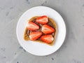 Toast with chocolate and strawberry, Single sandwich with chocolate cheese on white plate, top view Royalty Free Stock Photo