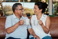 Toast, coffee and senior couple laughing in home, having fun and enjoying funny conversation. Love bonding, tea cheers Royalty Free Stock Photo