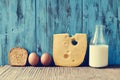 Toast, eggs, cheese and milk on a rustic wooden table, with a fi