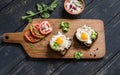 Toast with feta cheese and fried quail egg, fresh tomatoes on a dark wooden surface Royalty Free Stock Photo