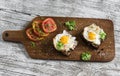 Toast with feta cheese and fried quail egg, fresh tomatoes on a light wooden surface Royalty Free Stock Photo