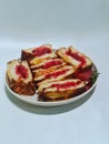 Toast filled with strawberry jam on a round plate