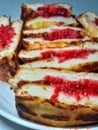 Toast filled with strawberry jam on a round plate
