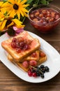 Toast with gooseberry jam. Wooden background flowers. Top view. Close-up