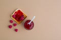 Toast with jam and raspberry on beige table. Top view