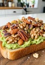 Toast with a layer of mashed avocado topped with a variety of nuts including Royalty Free Stock Photo