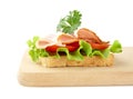 Toast,lettuce,tomato,cold cuts on cutting board on white Royalty Free Stock Photo