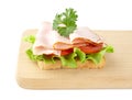 Toast,lettuce,tomato,cold cuts on cutting board on white Royalty Free Stock Photo