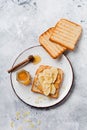 Toast with peanut butter, banana slices, honey and almond flakes on old gray concrete background. Royalty Free Stock Photo