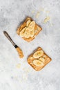 Toast with peanut butter, banana slices, honey and almond flakes on old gray concrete background Royalty Free Stock Photo