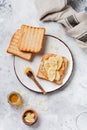 Toast with peanut butter, banana slices, honey and almond flakes on old gray concrete background. Royalty Free Stock Photo