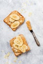 Toast with peanut butter, banana slices, honey and almond flakes on old gray concrete background. Top view Royalty Free Stock Photo