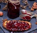 Toast with raspberry jam and empty jam jar with an iron spoon